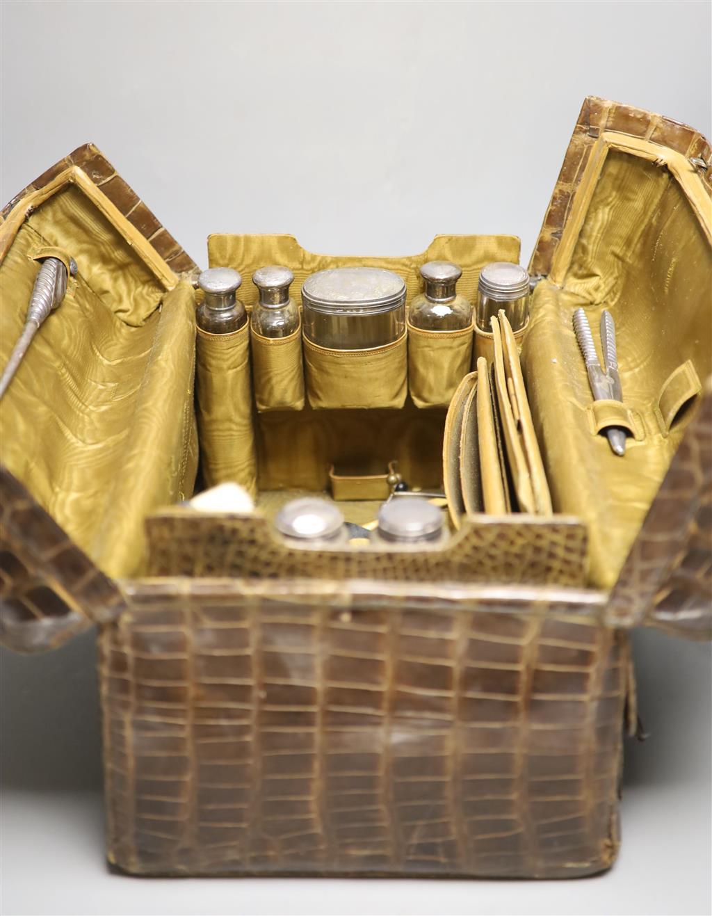 A late Victorian crocodile skin travelling toilet case